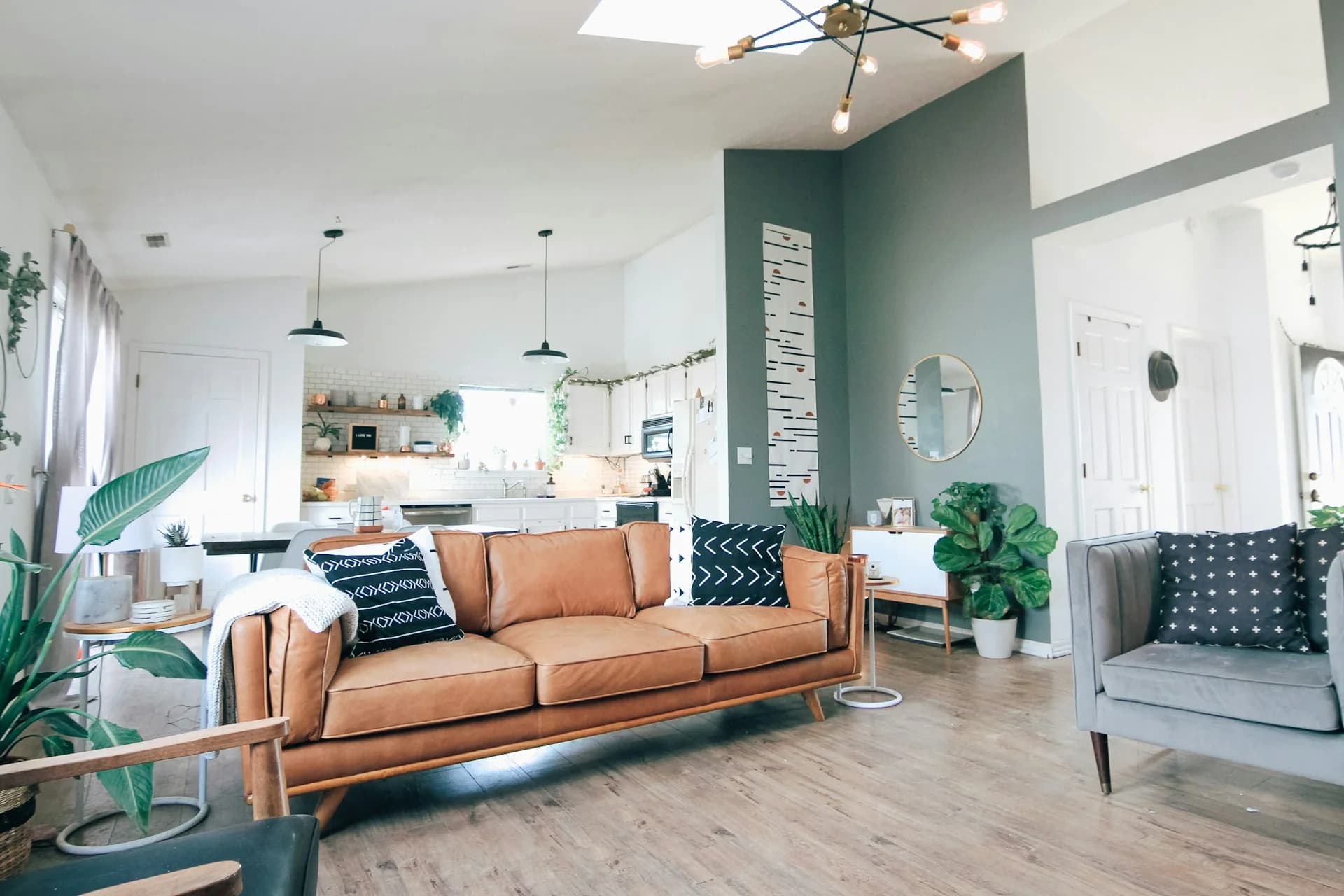 Espacio renovado con pared verde, piso de madera y muebles coordinados